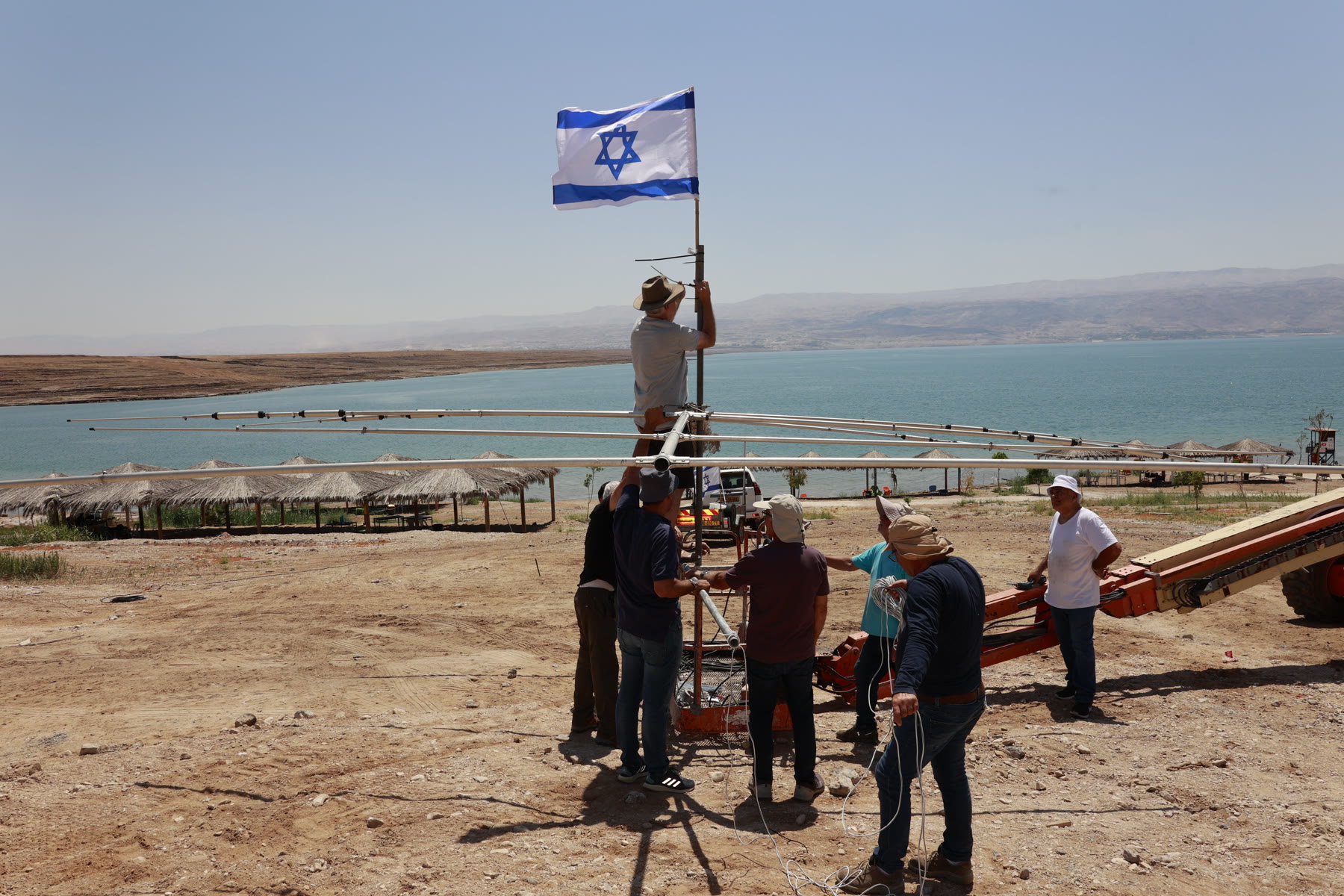 Radio operators carrying a yagi antenna beside the Dead Sea