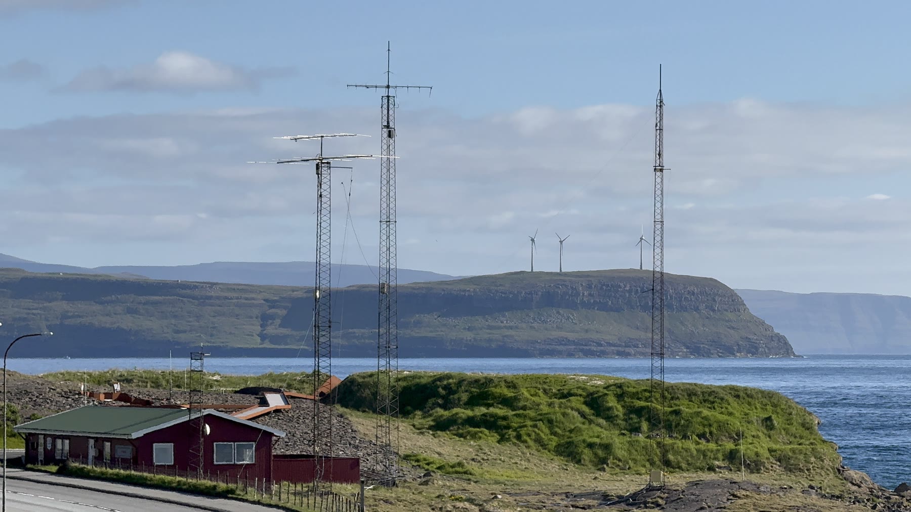 Antenna towers above a Faroe Islands coastal landscape